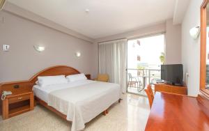 ein Schlafzimmer mit Bett, Fernseher und Balkon in der Unterkunft Hotel Marfil in Sant Antoni de Portmany