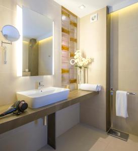 ein Badezimmer mit Waschbecken und Spiegel in der Unterkunft Hotel Marfil in Sant Antoni de Portmany + 53 Fotos