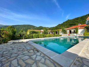 a swimming pool in front of a house at Hotel Opera Jaz in Budva