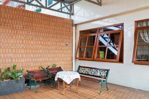 een patio met 2 banken, een tafel en een raam bij Wisma Rumka in Jakarta