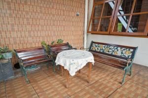 two benches and a table with a table cloth at Wisma Rumka in Jakarta