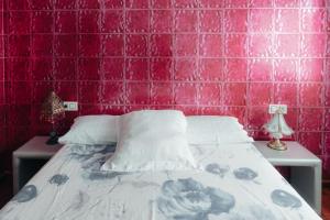 1 cama en una habitación con una pared de azulejos rosados en Moderno apartamento en el Camino de Fisterra, en Negreira