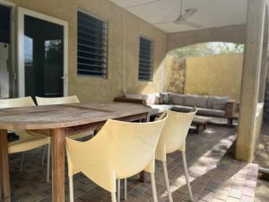 een houten tafel en stoelen op een patio bij Cocobana Resort two-bedroom apartment ground floor in Willemstad