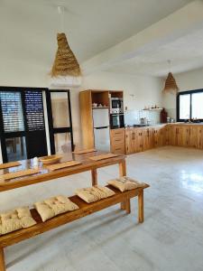 a large room with wooden tables and a kitchen at Villa Nour Kélibia in Kelibia