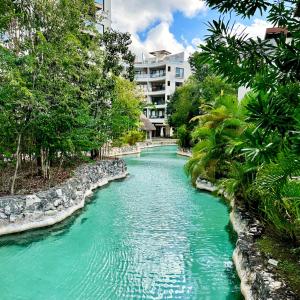 a river with turquoise water and trees and a building at Playa Del Carmen Apartment in Playa del Carmen