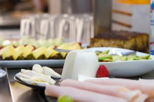 una mesa con un plato de comida y un bol de fruta en Hotel Marfil en San Antonio