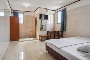 a bedroom with a bed and a bathroom at Wisma Rumka in Jakarta