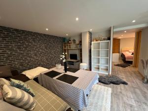 sala de estar con mesa y pared de ladrillo en Les Saisies - La petite Vardache - studio alcôve 27 m2 - 1 lit 140 - parking - local vélo, en Hauteluce