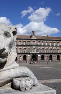 een standbeeld van een leeuw voor een gebouw bij FamilyHouse PIAZZA CARITA' in Napels
