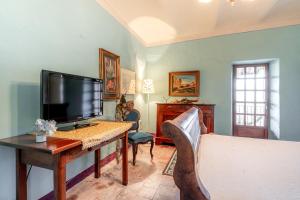 a living room with a tv and a table and a couch at Ca' Pavaglione Country House in Borgomale