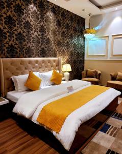 sypialnia z dużym łóżkiem i żółtym kocem w obiekcie Victorian Elegance Luxury Stays w mieście Amritsar