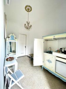 a kitchen with a chandelier and a chair in a room at Stile Libero Guest House in Turin