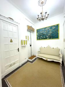 a white room with a couch and a painting on the wall at Stile Libero Guest House in Turin