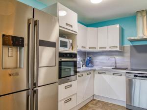 シス・フール・レ・プラージュにあるApartment Le clos pecheur by Interhomeの白いキャビネットとステンレス製の電化製品を備えたキッチン