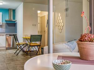 シス・フール・レ・プラージュにあるApartment Le clos pecheur by Interhomeのテーブルと椅子のあるキッチンとリビングルーム