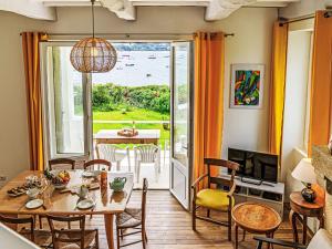 a living room with a table and chairs and a balcony at Holiday Home Maison La Prâme by Interhome in Arradon +15 photos