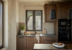 a kitchen with a sink and a window at Memorias Villas and Suites in Vasilikos
