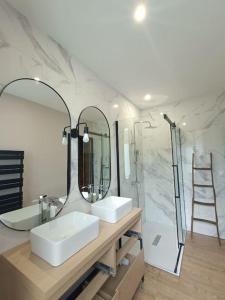 a bathroom with two sinks and a large mirror at # Le Beffroi# Maison# Murol in Murol