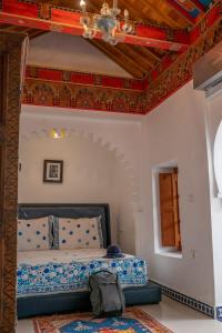 a bedroom with a bed and a chandelier at Lalla Ghayta in Chefchaouene