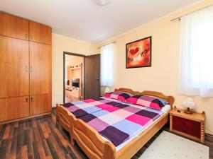 een slaapkamer met een groot bed en een kleurrijke deken bij Apartment Beige by Interhome in Balatonszemes