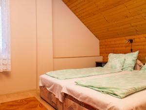 バラトンフェニヴェシュにあるHoliday Home Gerle by Interhomeの木製の天井の客室のベッド1台分です。 +9枚の写真