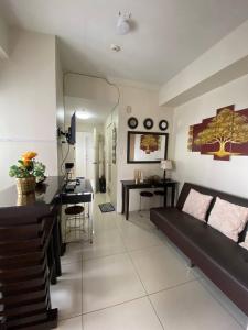 a living room with a black couch and a desk at D Luckycharm staycation in Tagaytay
