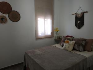 a bedroom with a bed with pillows and a window at Aparamento Playa Salou in Salou