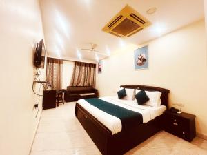 una camera d'albergo con letto e TV di Hotel Lagoona and Banquet Hall a Nuova Delhi