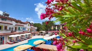 a resort with a swimming pool and tables and umbrellas at Konfor Suite Otel in Oludeniz
