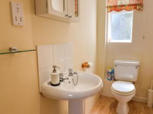 a bathroom with a white sink and a toilet at 50 Fernhill Heights in Bridport +18 photos