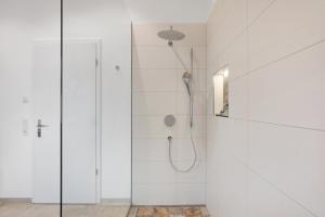 a white bathroom with a shower with a glass door at Chalet Foret - Ferienhaus in Todtnauberg +27 photos