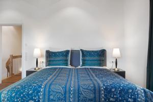 a bedroom with a blue bed with two blue pillows at Chalet Foret - Ferienhaus in Todtnauberg