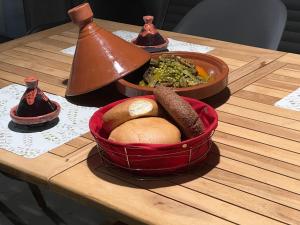 einen Tisch mit einer Schüssel Essen und einer Schüssel Brot in der Unterkunft Villa Naouma in Marrakesch