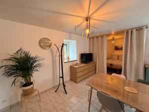 a living room with a table and a bedroom at La P'tite maison de Trého in Tréhorenteuc