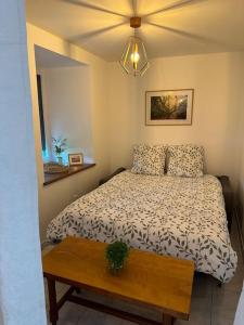 a bedroom with a bed and a wooden table at La P'tite maison de Trého in Tréhorenteuc