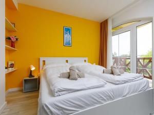 バラトンレッレにあるApartment Summer by Interhomeの黄色い壁の客室で、白い大型ベッド1台が備わります。