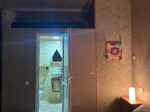 a bathroom with a door open to a bathroom with a sink at Ke&Ra Guestsroom in Gori