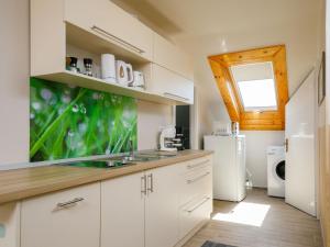 une cuisine avec des armoires blanches et un réfrigérateur blanc dans l'établissement Apartment Duma by Interhome, à Balatonkeresztúr 22 autres photos