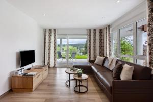 a living room with a brown couch and a television at Chalet Foret - Ferienwohnung in Todtnauberg