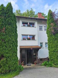 una casa bianca con fiori alle finestre di Apartma Cipresa a Rogatec