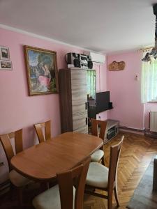 una sala da pranzo con tavolo e sedie in legno di Apartma Cipresa a Rogatec