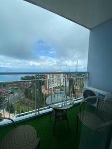 a balcony with a table and chairs and a view of the ocean at D Luckycharm staycation in Tagaytay
