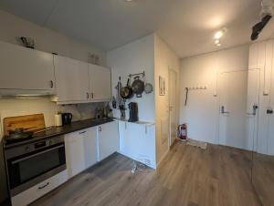 eine Küche mit weißen Schränken und einem Herd mit Backofen in der Unterkunft Spacious and cozy study apartment with balcony in Oslo