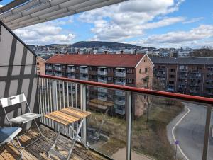 einen Balkon mit einer Bank und Stadtblick in der Unterkunft Spacious and cozy study apartment with balcony in Oslo