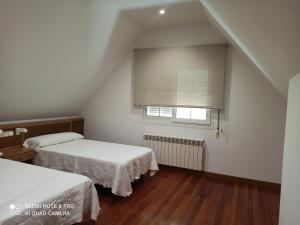Łóżko lub łóżka w pokoju w obiekcie Duplex en Sanxenxo con piscina y vistas al mar