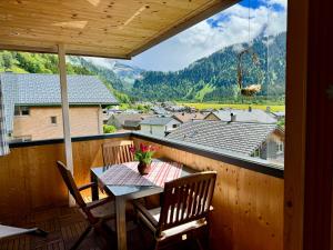 einen Tisch und Stühle auf einem Balkon mit Aussicht in der Unterkunft Ferienwohnung Schoppernau in Schoppernau