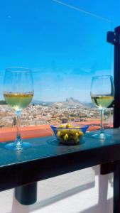 two glasses of wine on a table with a view at Apartamentos Antequera in Antequera