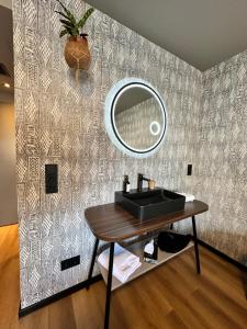 a bathroom with a sink and a mirror on a wall at Ratshotel - City Aparthotel Aalen in Aalen