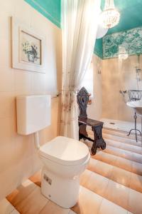 a bathroom with a white toilet and a sink at Ca' Pavaglione Country House in Borgomale