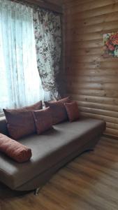 a couch with pillows on it in front of a window at Вежа in Bukovel